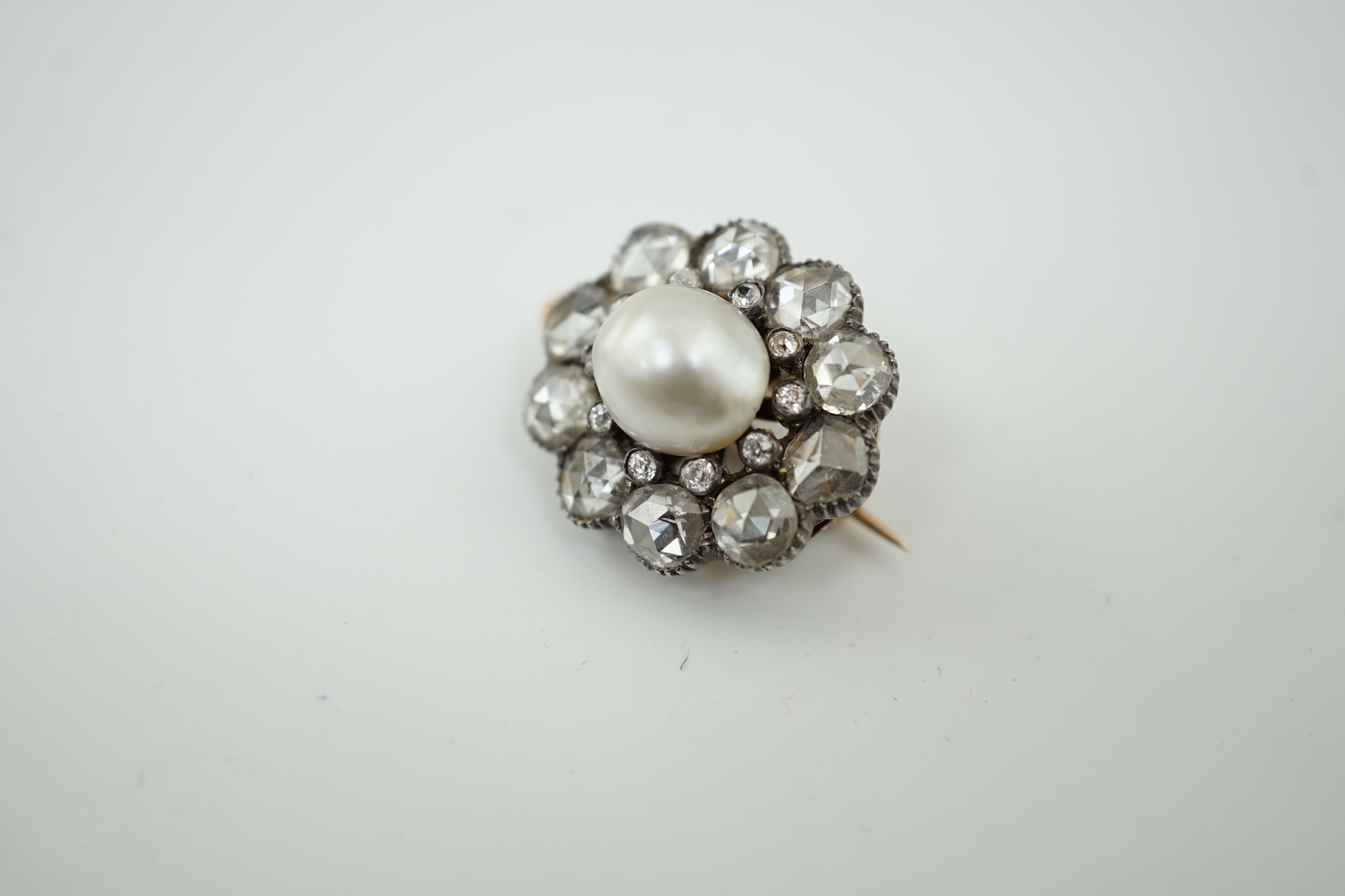 A 19th century gold and silver, single stone natural saltwater part drilled button pearl and rose and round cut diamond cluster set pendant brooch